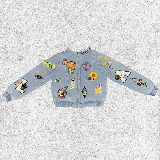 Light blue jacket with various colorful cosmic themed patches , quilted bomber front view.