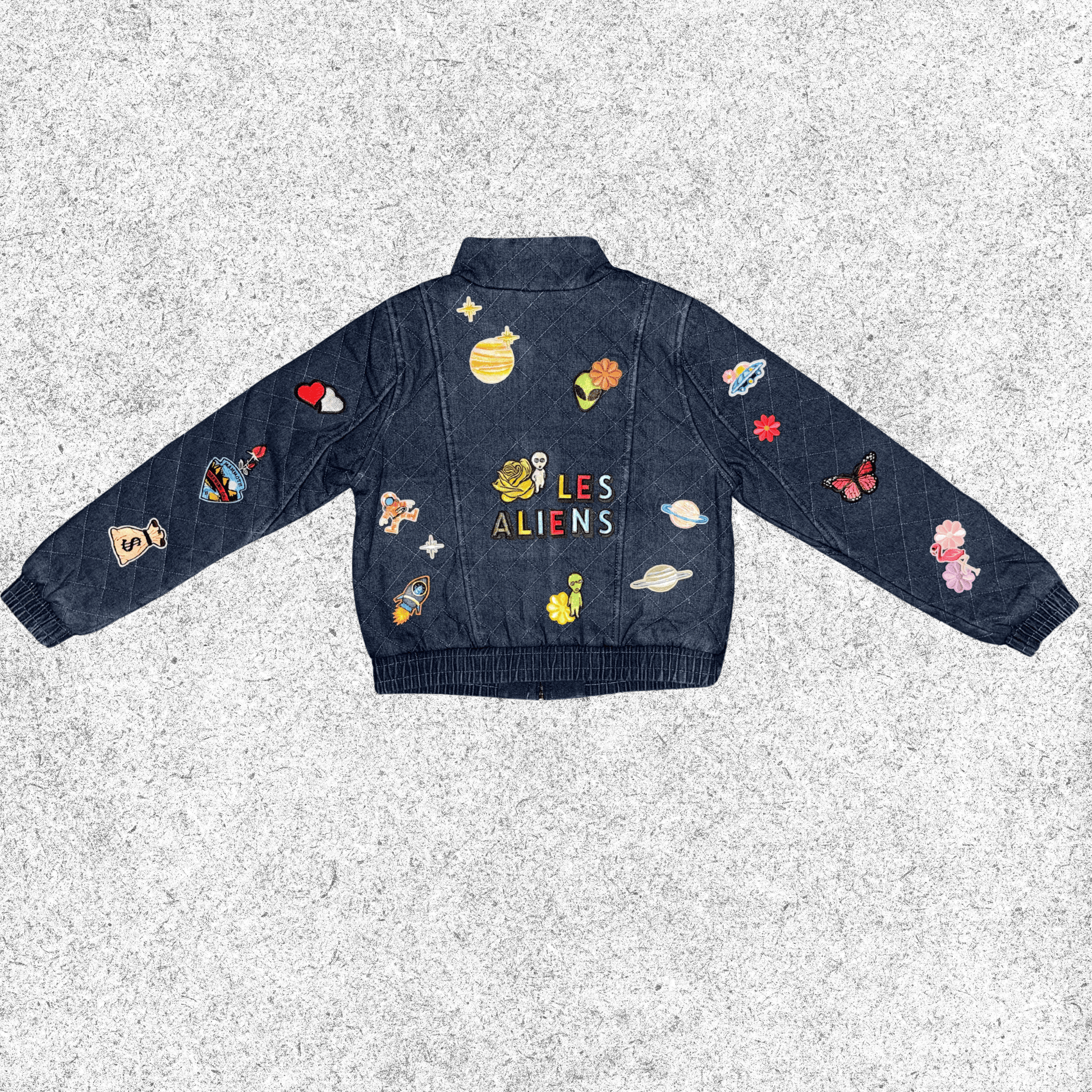 Denim jacket with colorful alien-themed patches back view.